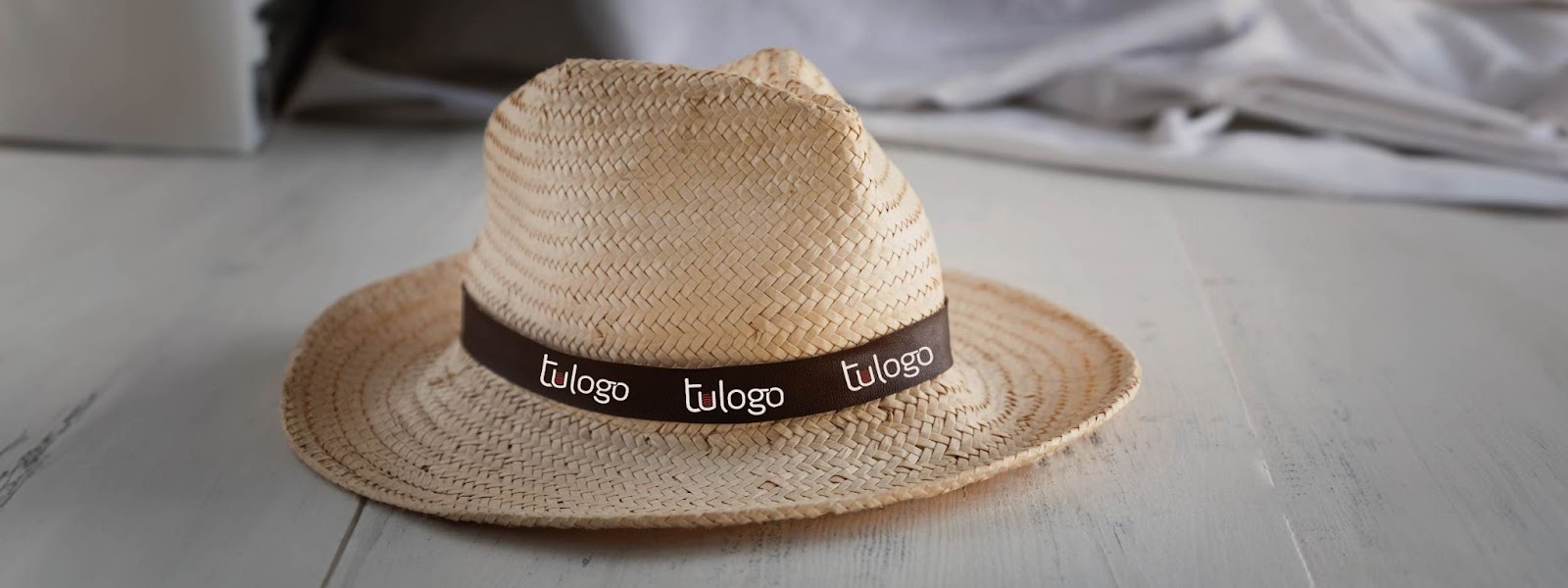 7 maneras de usar los sombreros de paja en tu estrategia de marketing 1 Sombrero de paja con una cinta alrededor con la frase "tu logo"