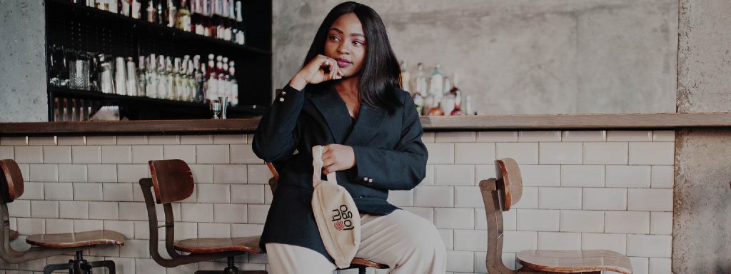 persona joven en un bar usando una riñonera personalizada