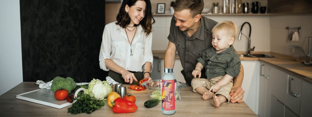 una familia cocinando juntos viendo una botella de cristal personalizada