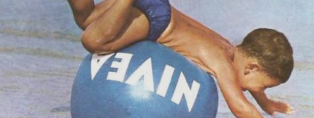 Niño jugando en la playa con una pelota Nivea en verano