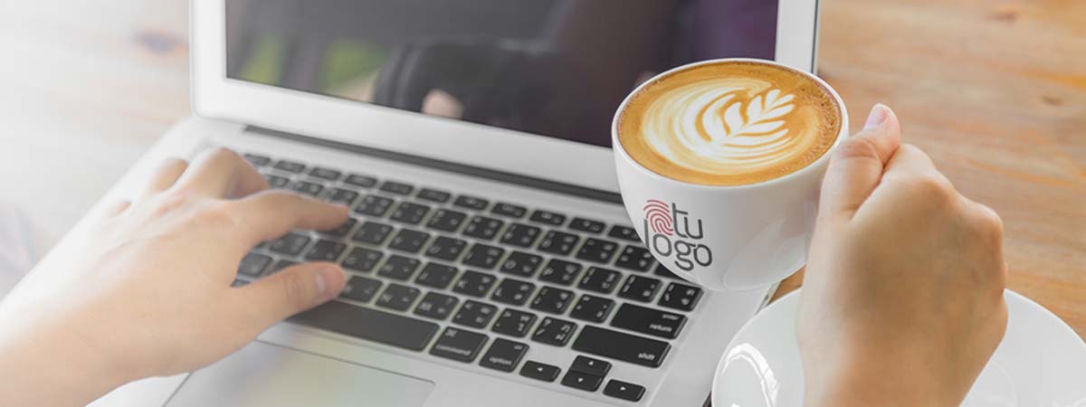 Empleado remoto con una taza de café personalizada con logo y una laptop