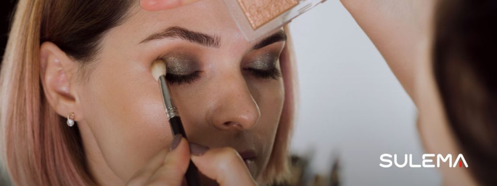 mujer maquillando a otra en una feria de cosmética