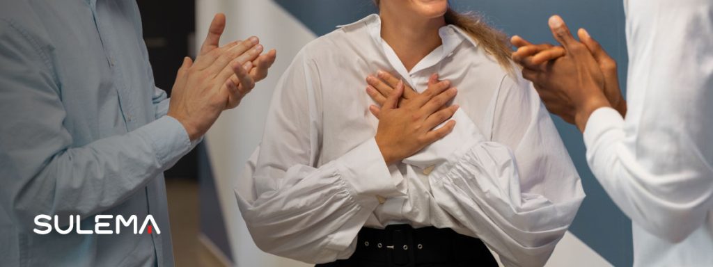 compañeros de trabajo aplaudiendo a una mujer por su trabajo